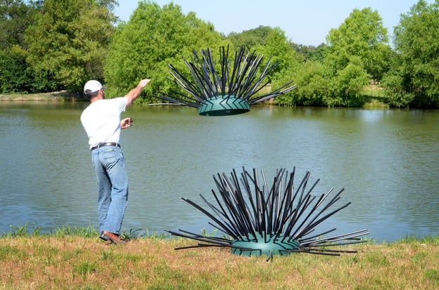 man throwing Honey Hole Shrub artificial fish habitat into pond