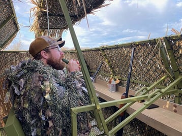 Hunter calling for ducks inside blind
