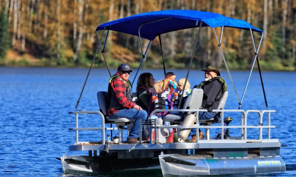 Family cruising on small pontoon boat with shade