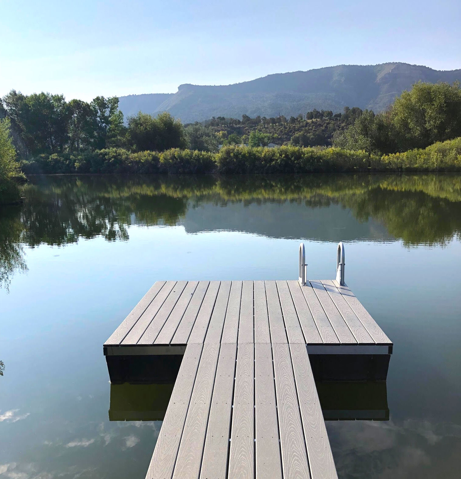 Aluminum dock in pond with mountains in background